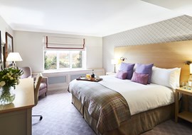 Manor House Suite with large kingsized bed with tartan interiors and wooden furniture and room service 
