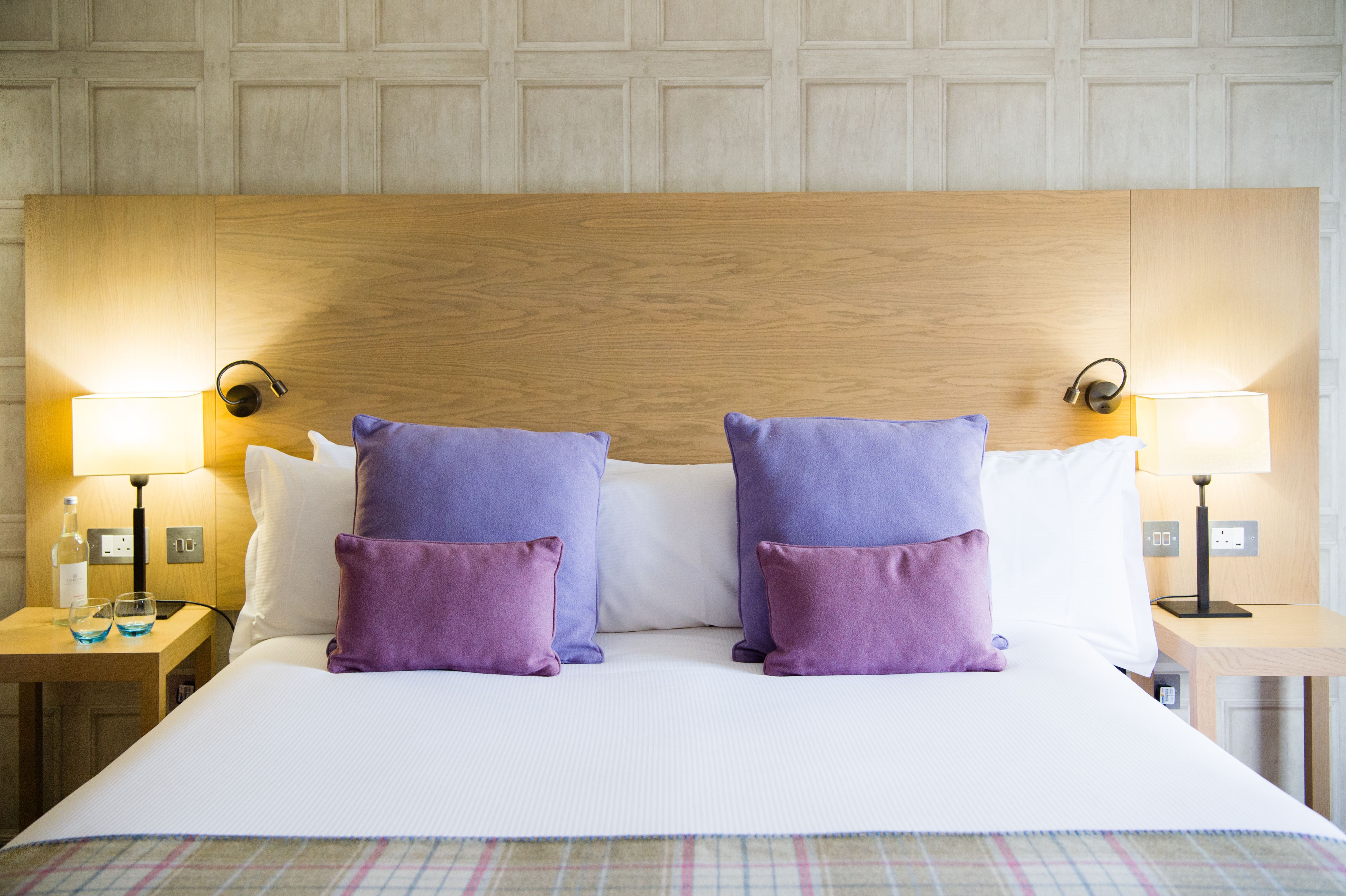 Superior Signature Double Bed with purple pillows and bedside lamps
