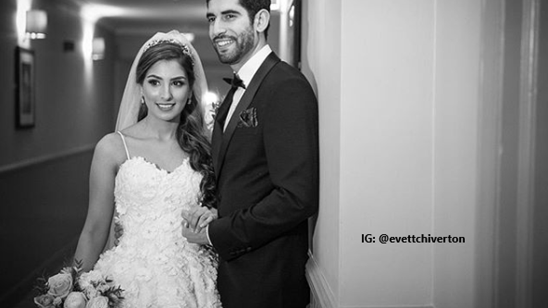 Bide and groom pose for photo in hallway after wedding