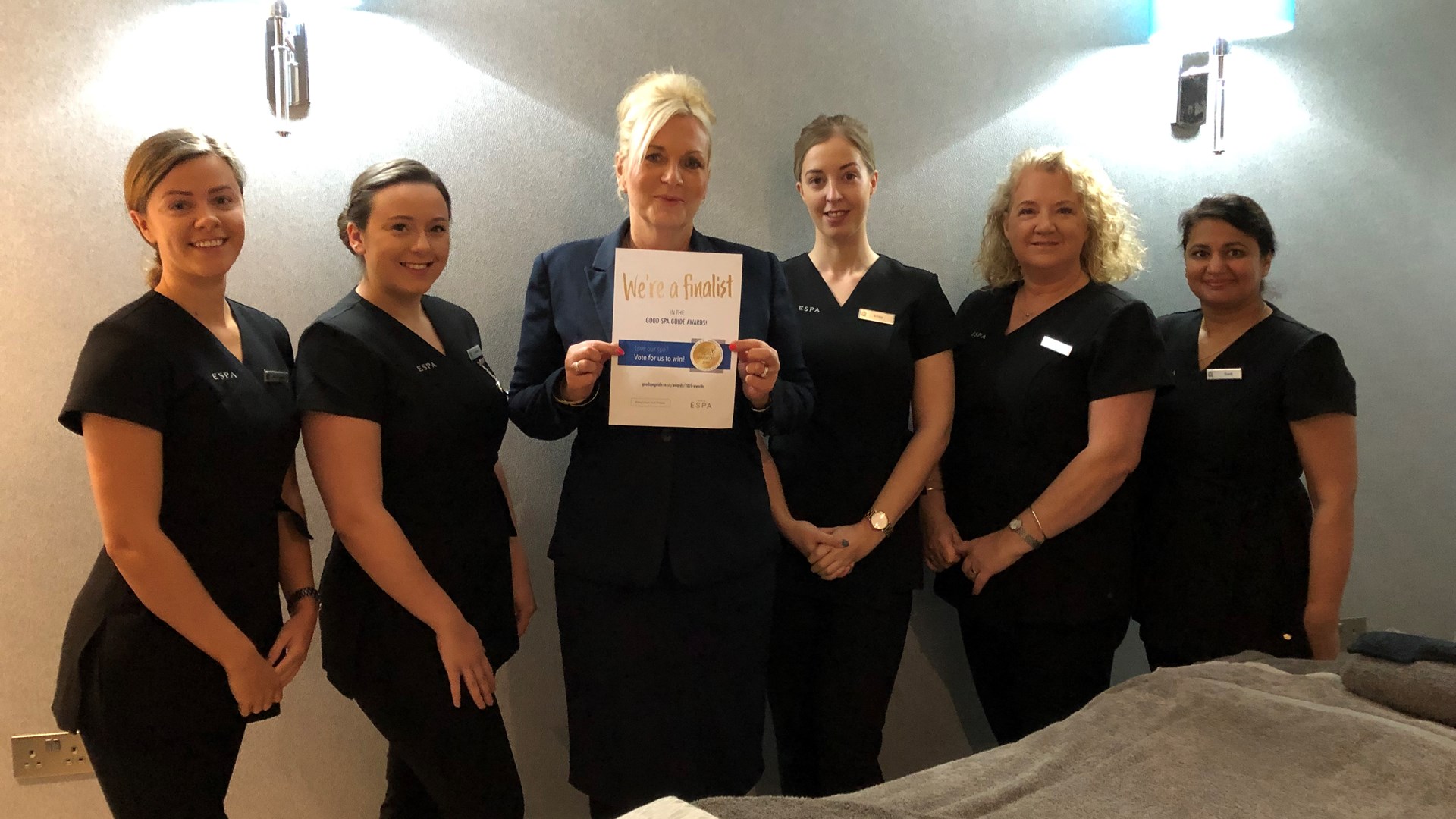 The Belfry Spa team pose with certificate outlining "We're a finalist in the good spa awards"