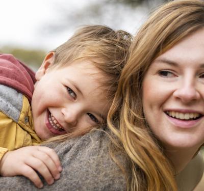 Happy Mother Holding Kid Back