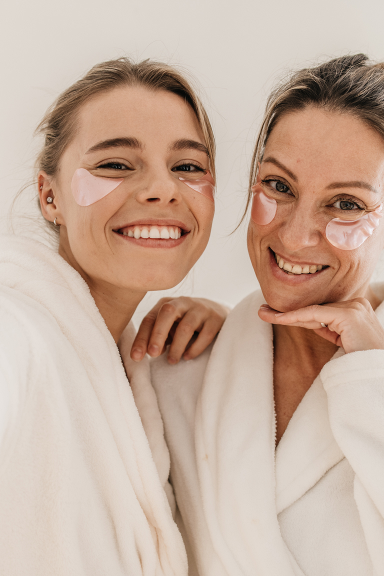 Happy Caucasian Women Use Eye Patches Wear Bathrobes Look Camera White Background Concept Preserving Youth