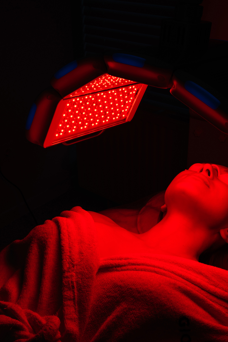 Side View Tracking Shot Relaxed Female Client Having Red Led Light Facial Photodynamic Therapy